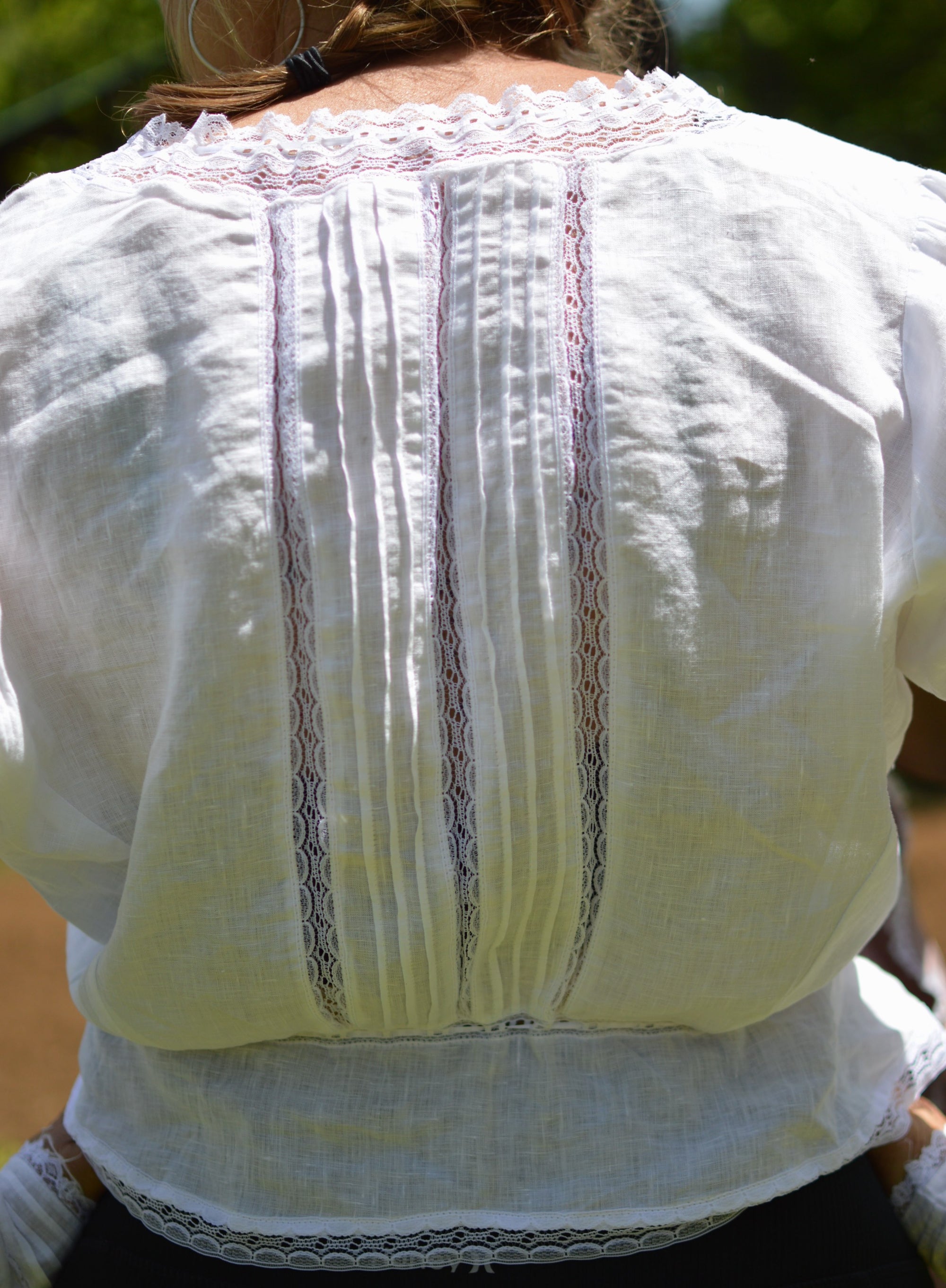 close up of back of long sleeved camisole in white with white insertion lace.