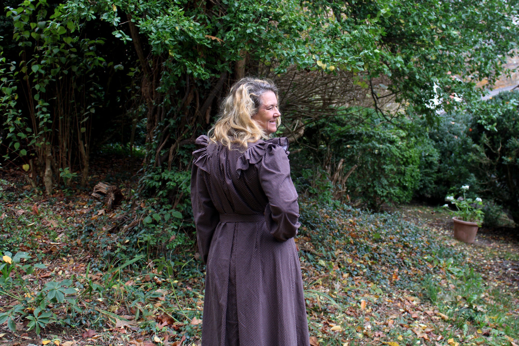 Close up of the back of the Calico Day Dress on a woman outside with her hand on her hip