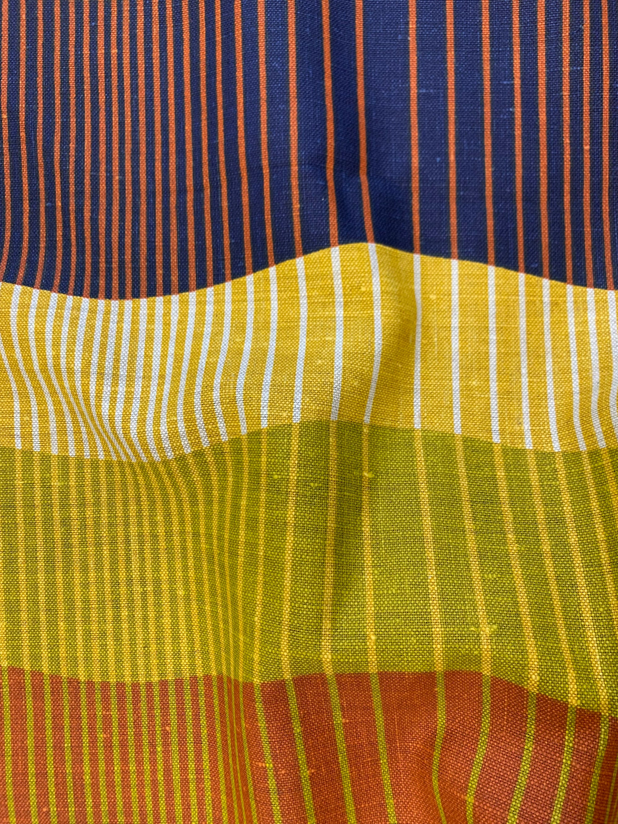 wavy horizontal stripes of chartreuse, orange and  indigo and vertical striped of white, mustard, chartreuse and orange. Linen fabric.